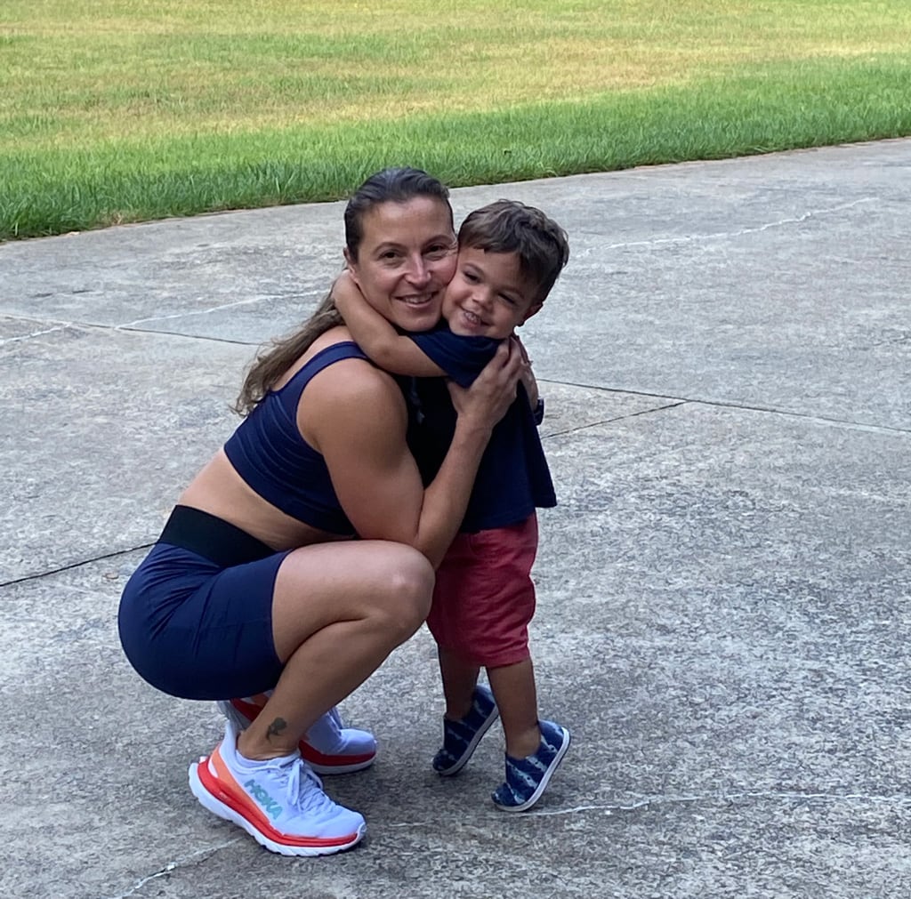 Coach in a workout outfit hugging her little son.